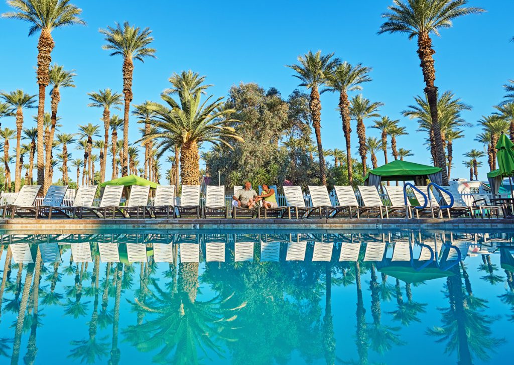 Couple sitting by the pool at Thousand Trails Palm Springs